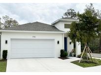 Charming one-story home featuring a two-car garage, modern design, and landscaping at 1790 White Orchid Ct, Sarasota, FL 34235