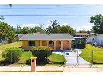 Charming home featuring an arched porch, gated yard, and a well-maintained lawn with mature landscaping at 2822 Maple Ave, Sarasota, FL 34234