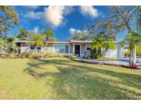 Charming single-story home with a well-manicured lawn, mature trees, and lush landscaping at 4147 Augustine Ave, Sarasota, FL 34231