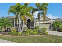 Charming one-story home with a well-manicured lawn and lush tropical landscaping at 7812 Birdie Bend Way, Sarasota, FL 34241