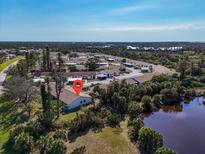 A lovely aerial view of a well-maintained community near a pond and lush trees at 6796 Gasparilla Pines Blvd # 45, Englewood, FL 34224