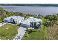 Stunning waterfront home featuring lush landscaping, a private dock, and ample space for luxurious coastal living at 9464 St Marys Ct, Port Charlotte, FL 33981