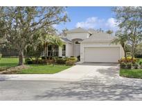 Charming one-story home featuring a manicured lawn, mature landscaping, and a two-car garage at 8134 Coates Row Pl, Bradenton, FL 34201