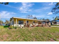 Charming single-story home features a large covered porch, a manicured lawn and mature landscaping at 1206 2Nd E Ave, Bradenton, FL 34208