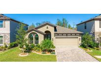 Charming single-story home featuring a well-manicured lawn, a two-car garage, and beautiful landscaping at 12750 Oak Hill Way, Parrish, FL 34219