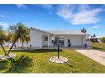 Charming single-story home with manicured lawn, beautiful palm trees, and a welcoming front entrance at 3708 Chinaberry Rd, Bradenton, FL 34208