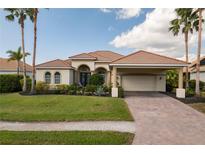 Inviting single-story home with a tile roof, lush landscaping, and covered carport entrance at 4721 Mainsail Drive, Bradenton, FL 34208
