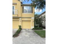 Charming townhouse featuring two garage doors and neatly manicured landscaping at 6768 Breezy Palm Dr, Riverview, FL 33578