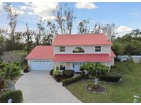 Charming two-story home with a red roof, lush lawn, and mature landscaping at 9142 16Th Avenue Nw Cir, Bradenton, FL 34209