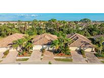Charming townhome featuring a tile roof, a two-car garage, and lush landscaping at 20170 Benissimo Dr, Venice, FL 34293