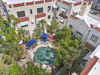 Aerial view of a community pool surrounded by lounge chairs and lush landscaping at 210 N 17Th W St # 12, Bradenton, FL 34205