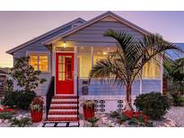 Charming home with a bright red door, complemented by lush landscaping and a quaint, inviting appeal at 310 S Osprey Ave, Sarasota, FL 34236