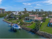 Waterfront home featuring a private dock, a swimming pool, lush landscaping and gorgeous palm trees at 364 El Greco Dr, Osprey, FL 34229