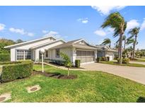 Charming home featuring a two-car garage, well-manicured lawn, and beautiful palm trees against a clear blue sky at 4528 Fern Dr, Bradenton, FL 34208