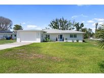 Charming single-story house with blue door and a spacious well-maintained lawn at 400 Dona Dr, Nokomis, FL 34275