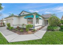 Charming home exterior with manicured landscaping, awning-covered windows, and a paved walkway at 4410 Murfield E Dr, Bradenton, FL 34203