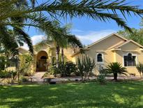 Charming home featuring lush landscaping, manicured lawn, and a welcoming front entrance with a brick walkway at 15207 17Th E Ave, Bradenton, FL 34212
