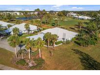 Beautiful home featuring a well-maintained yard, mature palm trees, and golf course view at 276 Cerromar Way # 60, Venice, FL 34293