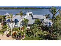 Stunning waterfront home with lush landscaping and a metal roof offers luxury living at 741 Hideaway Bay Dr, Longboat Key, FL 34228