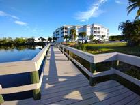 Picturesque water view of the condo complex from a wooden dock surrounded by lush landscaping at 2001 Bal Harbor Blvd # 2301, Punta Gorda, FL 33950