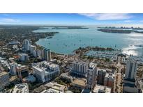 Stunning aerial view of waterfront city buildings and harbor, with boats sailing in the blue waters at 101 S Gulfstream Ave # 7B, Sarasota, FL 34236