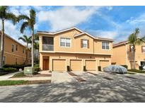 Charming townhome with three garage spaces, stucco facade, and tropical landscaping with palm trees at 3823 Parkridge Cir # 1-101, Sarasota, FL 34243