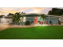 Charming single story home with bright blue paint, a front yard, and a coral front door at 408 Bryn Mawr Is, Bradenton, FL 34207