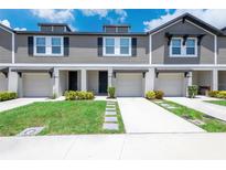 Inviting townhomes with attached garages, well-maintained lawns, and stone walkway at 17136 Blowfish Dr, Nokomis, FL 34275