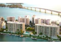 Stunning aerial view of waterfront condos with boat docks, pool, and bridge access to nearby islands at 590 Golden Gate Point # 506, Sarasota, FL 34236