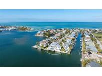 Stunning aerial view of waterfront home with private dock and pool, surrounded by beautiful ocean scenery at 624 N Point Dr, Holmes Beach, FL 34217