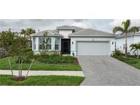 Charming single-story home featuring a two-car garage, tiled roof, and beautifully landscaped front yard at 9978 Bright Water Drive, Englewood, FL 34223