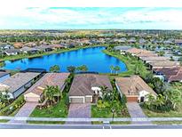 Beautiful aerial view of homes surrounding a lake, complemented by lush landscaping and clear blue skies at 16741 Ellsworth Ave, Bradenton, FL 34202