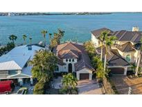 Beautiful home near the water features a well-manicured lawn, tropical landscaping, a private driveway, and an attached garage at 244 N Washington Dr, Sarasota, FL 34236