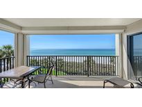 Spacious balcony with seating offering unobstructed views of the ocean and pristine sandy beach at 2675 Gulf Of Mexico Dr # 301, Longboat Key, FL 34228