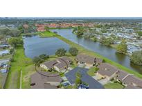 Aerial view of waterfront townhome community with mature landscaping and tranquil lake at 3119 Glen Elyn Blvd # 9, Sarasota, FL 34237