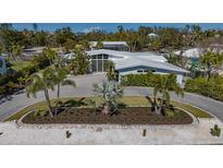 Stunning single-story home with lush landscaping, circular driveway, and modern architectural design at 619 Buttonwood Dr, Longboat Key, FL 34228