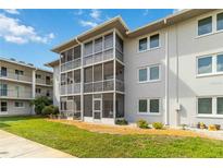 Condo building exterior features screened balconies, well-maintained landscaping, and neutral paint at 649 S Tamiami Trl # 210, Venice, FL 34285