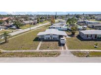 Single-story home showcasing front lawn, long driveway, and a light-grey roof at 211 Dalton Blvd, Port Charlotte, FL 33952
