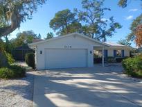 Charming single-story home featuring a well-maintained lawn and a two-car garage at 2428 Whippoorwill Cir, Sarasota, FL 34231