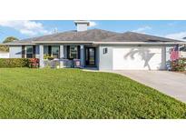 Charming single-story home featuring lush green lawn, inviting front porch and attached two-car garage at 432 W Gate Dr, Venice, FL 34285