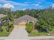 A beautiful single-Gathering home with a three-car garage surrounded by lush trees and landscaping at 7911 Kavanagh Ct, Sarasota, FL 34240