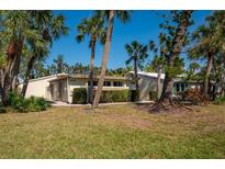 Charming single-story home featuring tropical landscaping, a well-manicured lawn, and a welcoming facade at 231 Hourglass Way # V5, Sarasota, FL 34242