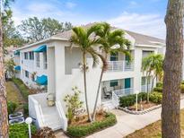 Inviting condo exterior with well-kept landscaping and blue awnings on the multiple balconies at 312 108Th W St, Bradenton, FL 34209