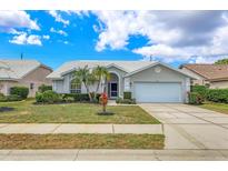 Charming single-story home with well-manicured lawn, mature palms, and a two-car garage at 6409 Stone River Rd, Bradenton, FL 34203