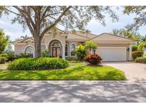 Charming single-story home with a well-manicured lawn, mature trees, and a two-car garage at 6922 Stanhope Pl, University Park, FL 34201