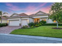 Charming single-story home with a well-manicured lawn, lush landscaping, and a three-car garage at 8284 Barton Farms Blvd, Sarasota, FL 34240