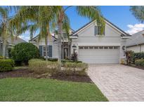 Charming single-story home featuring manicured landscaping, a paver driveway, and a two-car garage at 11728 Strandhill Ct, Lakewood Ranch, FL 34202