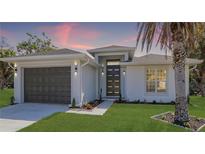 Charming single-story home with a well-manicured lawn, a gray garage door, and a modern front door at 1471 Palmwood Dr, Sarasota, FL 34232