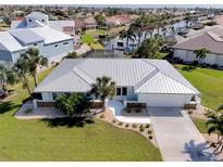 Beautiful waterfront home with a metal roof, lush landscaping, and access to canals at 2501 W Marion Ave, Punta Gorda, FL 33950