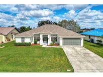 Charming single-story home with a well-manicured lawn and a two-car garage at 26052 Salonika Ln, Punta Gorda, FL 33983